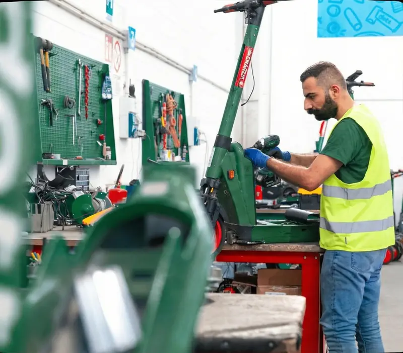 A ROULY mechanic in a safety vest working at the repair bench